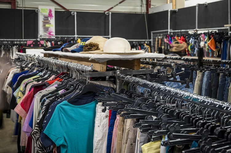 Rekken met tweedehands en vintage kleding in kringloopwinkel 't Tweede Kansje in Hilvarenbeek